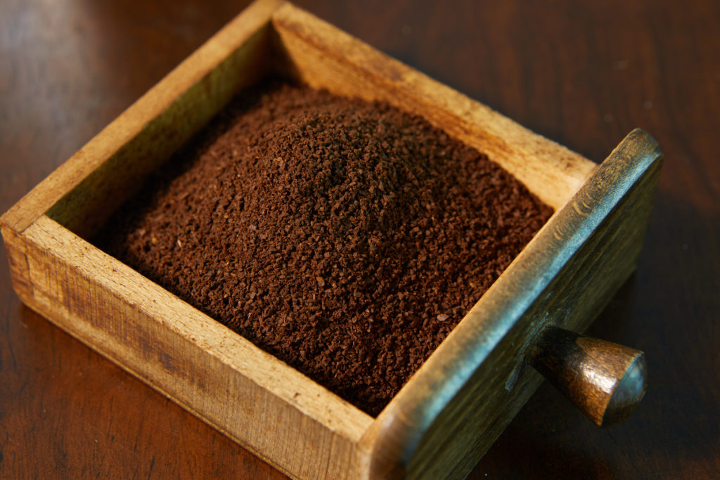 Ground coffee in a wooden box.