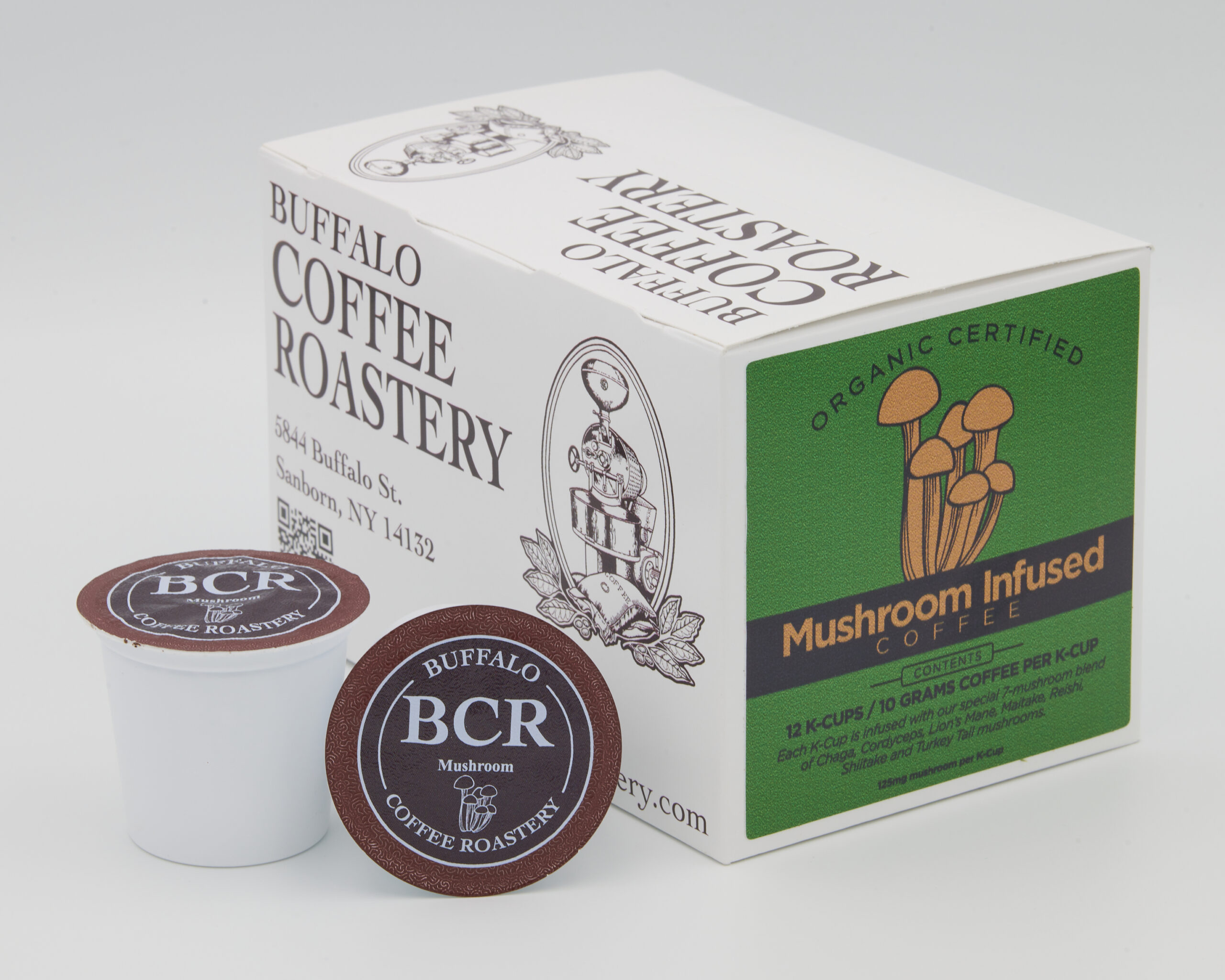 Two K-Cups next to a box of mushroom infused coffee.